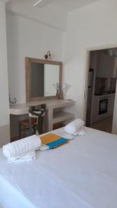 - une chambre avec un lit blanc et des serviettes dans l'établissement Flora Apartments, à Drios