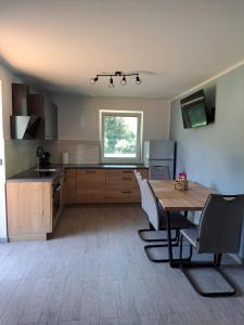 a kitchen with a wooden table and a dining room at Apartments Kolačko in Bohinj