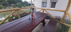 - un banc en bois sur un balcon avec 2 verres à vin dans l'établissement Lali Apartman, à Balatonudvari