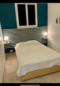 ein Schlafzimmer mit einem Bett und zwei Lampen an der Wand in der Unterkunft Le petit Versailles in Arles
