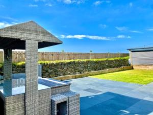 a backyard with a stone wall and a patio with a umbrella at Shackled-Am-Not in Camelford