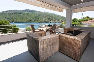 a balcony with wicker furniture and a view of the water at ANASSA PORTO KOUFO Sea front suites in Porto Koufo