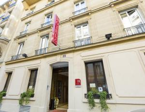 um edifício com uma placa na frente dele em Elysees Niel Hotel em Paris