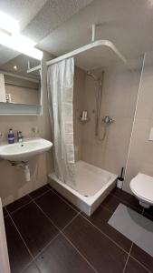 a bathroom with a shower and a sink at Esencial Apartment Interlaken in Interlaken