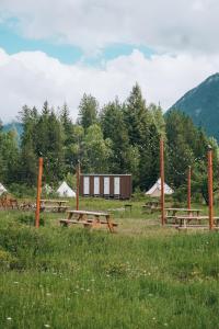 un gruppo di tavoli da picnic in un campo di Wander Camp Glacier a Coram