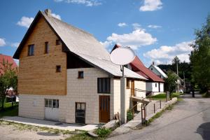 a barn with a satellite dish in front of a street at Srna Chalet - Rooms in Žabljak