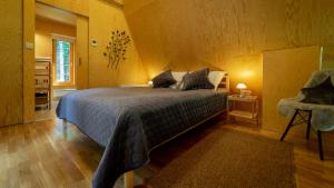 1 dormitorio con 1 cama y 1 silla en Forest House Stella - A frame cabin en Mrkopalj