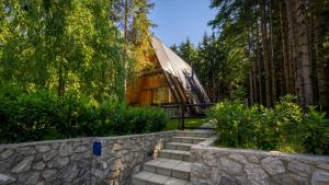a building with stairs and a stone wall at Forest House Stella - A frame cabin in Mrkopalj