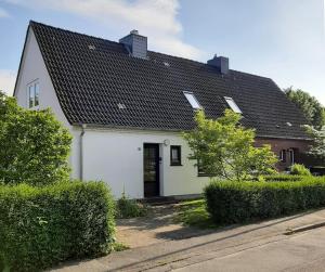 a white house with a black roof at Windrose - 95102 in Eckernförde