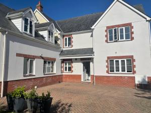 a white house with a brick driveway at Neema in Barnstaple