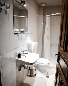 a white bathroom with a sink and a toilet at Shamrock Elati Retreats in Elati