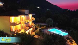 an aerial view of a building and a swimming pool at night at Ionis Studios in Lefkada