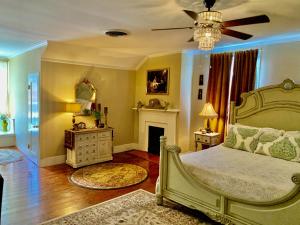 1 dormitorio con 1 cama y ventilador de techo en The Beaumont House Natchez, en Natchez