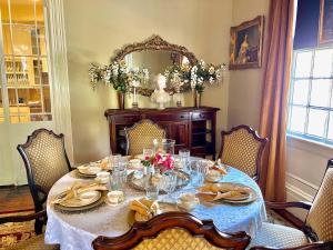 a dining room table with a blue table cloth and a mirror at The Beaumont House Natchez in Natchez