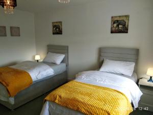 a bedroom with two beds and two lamps and a bed sidx sidx sidx at Cottage with Panoramic Views in Kirk of Shotts