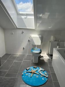 a bathroom with a toilet and a starfish rug at Schwarzwald Appartement Steffanie in Freudenstadt +6 photos