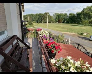 a balcony with a bunch of flowers on a house at Privatni smestaj - Rooms in Dobrosin