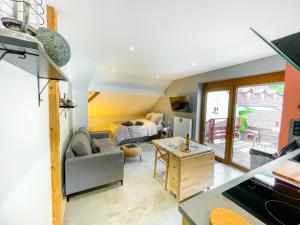 uma sala de estar com um sofá e uma cama em Gîte du Silberwald charmant gîte avec spa - jacuzzi , accès privatif em Stosswihr