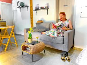 a woman sitting on a couch reading a book at Gîte du Silberwald charmant gîte avec spa - jacuzzi , accès privatif in Stosswihr