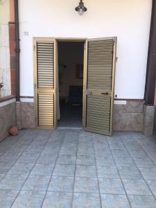 Deux portes en bois s'ouvrent dans une pièce. dans l'établissement La Casetta Bianca Vicino Mare, à Vibo Valentia Marina