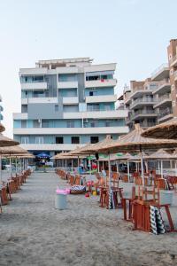 une plage avec des chaises et des parasols et un grand bâtiment dans l'établissement BEACHSITE, à Vlorë