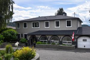 a large gray house with a white garage at A Touch of English B&B in Kelowna