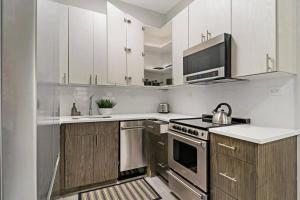 a kitchen with white cabinets and a stove top oven at Wonderful 2-Bedroom Apt near Restaurants - Hubbard 4 in Chicago