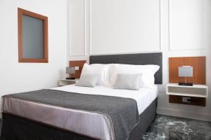 um quarto branco com uma cama grande e almofadas brancas em Domus Prestige -Suite Repubblica- In Central Rome em Roma
