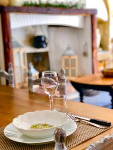 a table with a plate and a glass of wine at Chez Luis et David in Avignonet-de-Lauragais