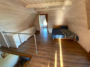 Habitación con cama y escalera en una cabaña en Sodyba Anykščių raj. en Anykščiai
