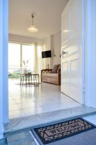 una puerta abierta a una sala de estar con sofá en Minimal Sea House en Avia