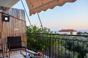 a balcony with a chair and an umbrella at Minimal Sea House in Avía