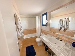 a bathroom with a sink and a toilet and a mirror at Apartamento Vilem & Piscina, Wi-Fi in Costa Calma