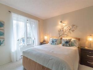 a bedroom with a large bed and a window at Superbe condo bord de l'eau à Magog in Magog-Orford