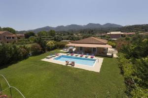a backyard with a swimming pool and a house at Villa Stafili by Villa Plus in Litherés
