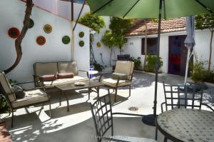un patio con mesa, sillas y sombrilla en La Vieja Parra, en La Puerta de Segura