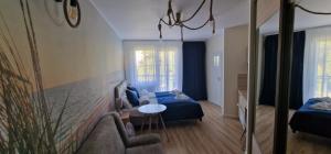 Pokój z kanapą, łóżkiem i stołem w obiekcie Apartamenty Hexagon nr 11 w Grzybowie