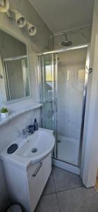 biała łazienka z prysznicem i umywalką w obiekcie Apartamenty Hexagon nr 11 w Grzybowie +24 zdjęcia