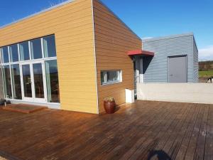 a house with a wooden deck with a building at Luxury home surronded with extraordinary nature in Selfoss