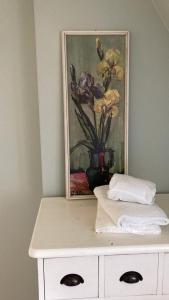 een schilderij van bloemen in een vaas op een dressoir bij Pferdekopfhaus in Traben-Trarbach