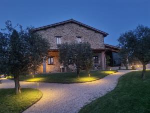 una casa de piedra con árboles delante de ella en Agriturismo Caiferri con spa en Gubbio