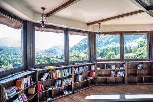 a room with bookshelves and windows with mountains at Transylvanian Inn in Bran