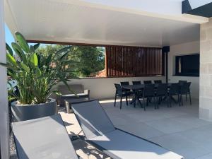 a patio with a table and chairs and a plant at Villa Aréna à Labenne-Océan in Labenne