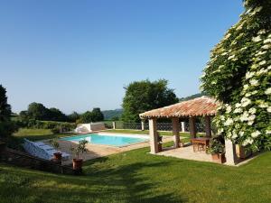 un patio trasero con piscina y cenador en Agriturismo Caiferri con spa en Gubbio