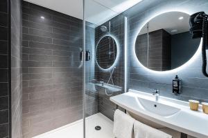 une salle de bain avec une douche, un lavabo et un miroir dans l'établissement Hotel ibis Lisboa Saldanha, à Lisbonne