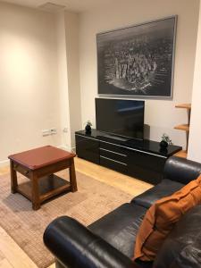 uma sala de estar com um sofá e uma televisão em Apex Fox Street Apartment with Free Parking em Glasgow