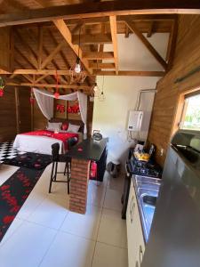 a room with a bed and a kitchen with a table at Cabana Dois Amores. Destino romântico. in Barracão