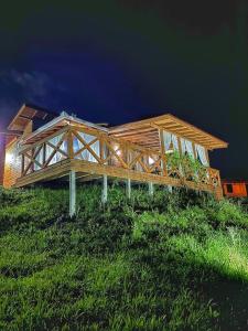 a wooden house on top of a green hill at Cabana Dois Amores. Destino romântico. in Barracão