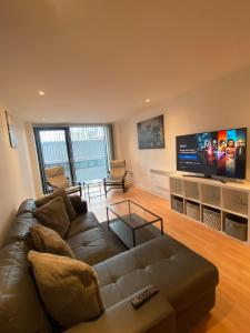 sala de estar con sofá y TV de pantalla plana en SECC&HYDRO BeAUTIFUL 2BR APARTMENT WITH FREE PARKING, en Glasgow