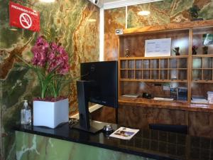 a desk with a computer and flowers on it at Hostal Oricáin in Oricáin